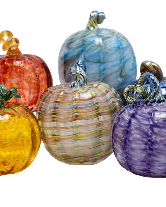 Six glass-blown pumpkins of various sizes and shapes.