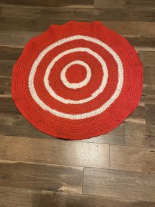 Circular red and white crocheted rug