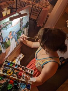 photo from above of a girl with brown hair painting a wedding portrait