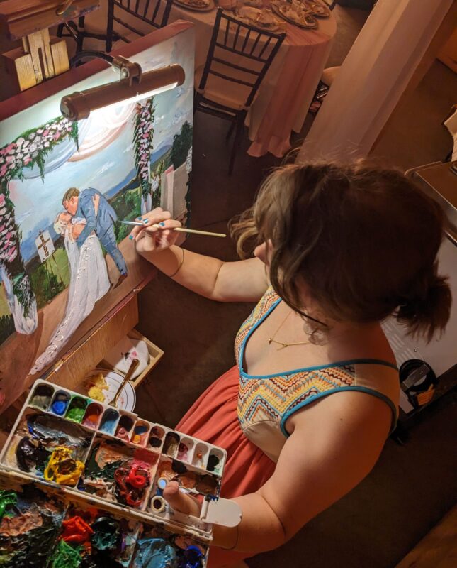 photo from above of a girl with brown hair painting a wedding portrait